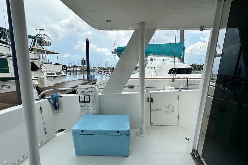 Slide: The Image of Deck view of 2001 Prima 52 Seahorse yacht with blue cooler and marina background. - 19