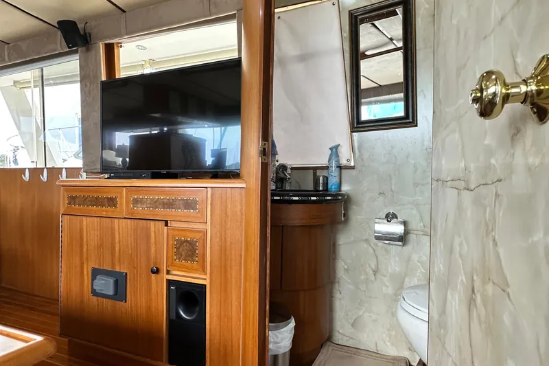 Slide: The Image of Interior of 2001 Prima 52 Seahorse yacht with TV, wooden cabinetry, and compact bathroom. - 30