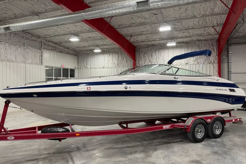The Image of 2004 Crownline 266 BR boat on red trailer in indoor storage facility. - 1