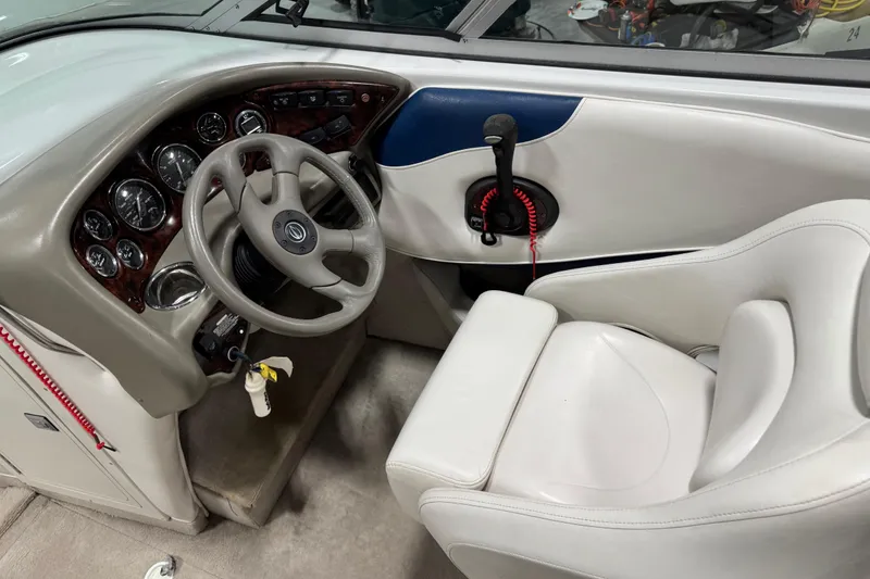 Slide: The Image of 2004 Crownline 266 BR boat cockpit with steering wheel and control panel. - 10