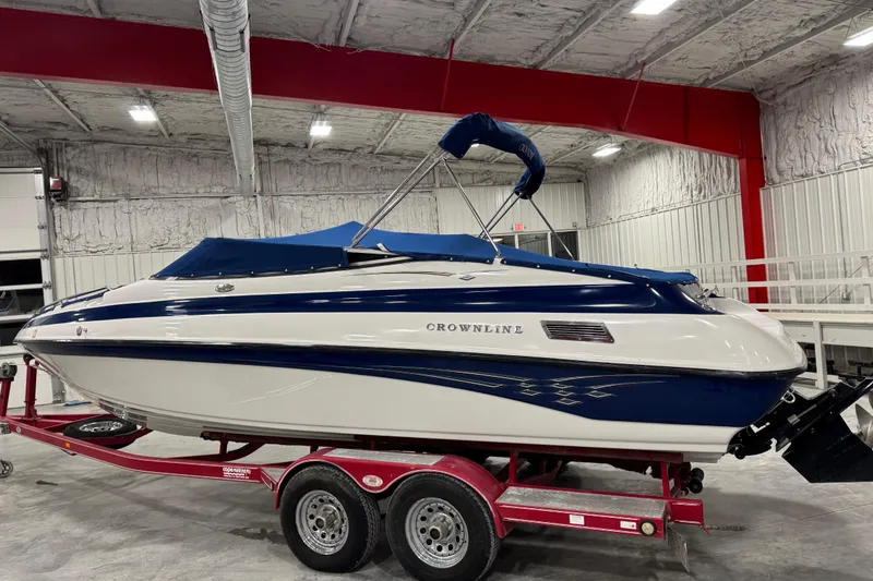 Slide: The Image of 2004 Crownline 266 BR boat on red trailer in indoor storage facility. - 11