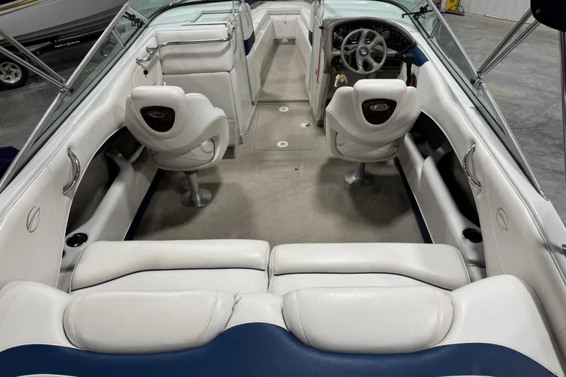 Slide: The Image of 2004 Crownline 266 BR boat interior with white seating and steering wheel. - 6