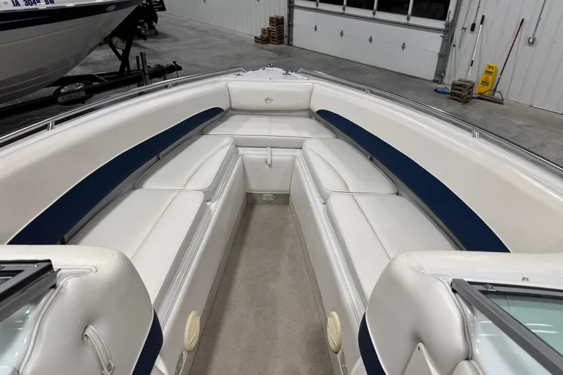Slide: The Image of 2004 Crownline 266 BR boat interior with white and blue seating in a garage. - 9