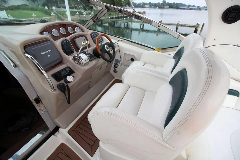 Slide: The Image of 2005 Sea Ray 340 Sundancer helm with white leather seats and navigation controls. - 10