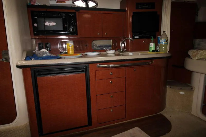 Slide: The Image of Interior of 2005 Sea Ray 340 Sundancer boat with kitchenette and wooden cabinetry. - 15