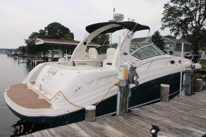 Slide: The Image of 2005 Sea Ray 340 Sundancer docked at a marina, showcasing sleek design and luxury features. - 4