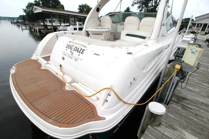 Slide: The Image of 2005 Sea Ray 340 Sundancer docked, featuring spacious deck and elegant design. - 6