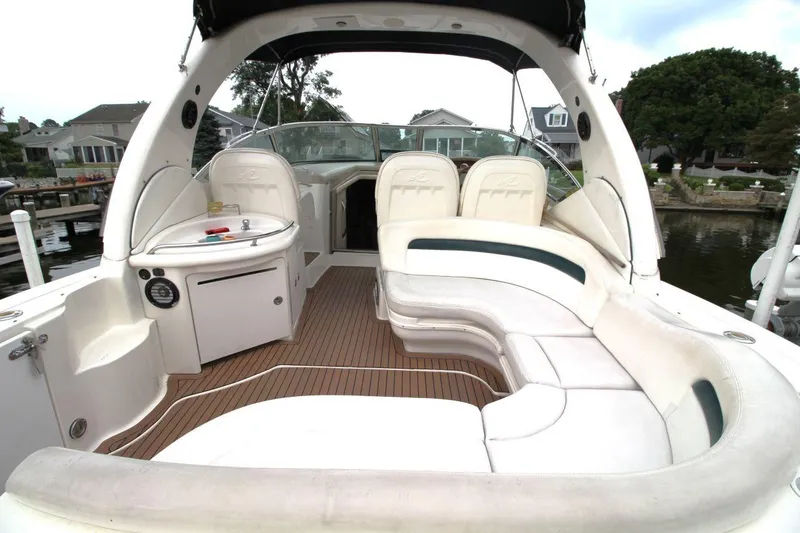 Slide: The Image of 2005 Sea Ray 340 Sundancer boat interior with white seating and wood flooring. - 7
