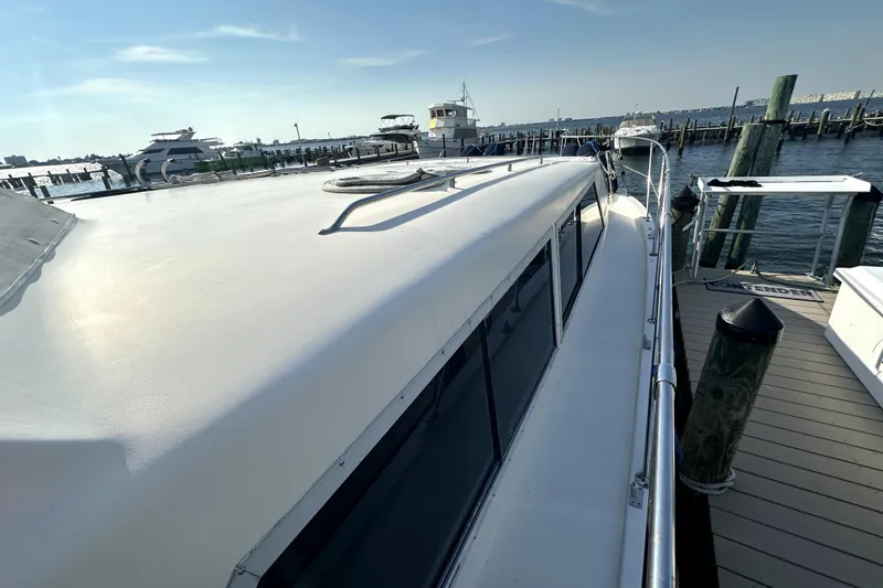 Slide: The Image of 1985 Chris-Craft 500 Constellation yacht docked at marina, sunny day, calm waters. - 100