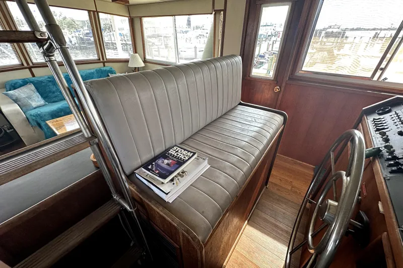 Slide: The Image of 1985 Chris-Craft 500 Constellation interior with helm seat, steering wheel, and nautical books. - 101