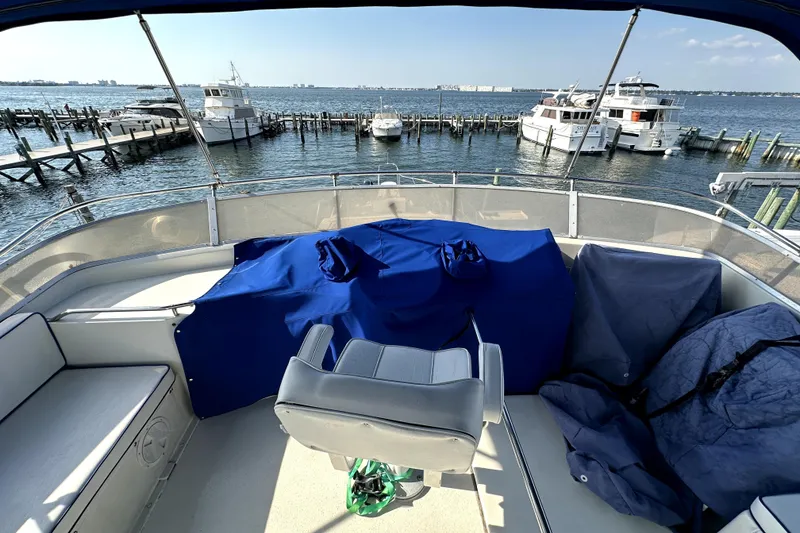 Slide: The Image of 1985 Chris-Craft 500 Constellation yacht interior with marina view, featuring covered seating and helm. - 110