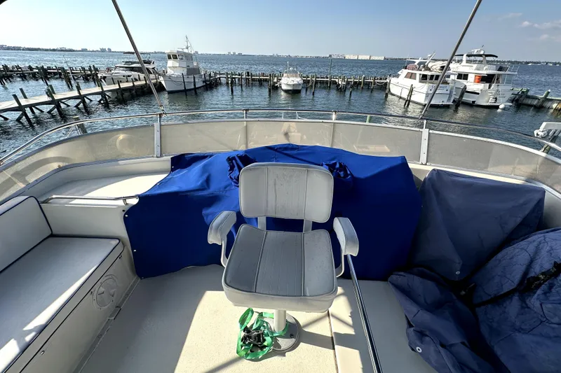 Slide: The Image of 1985 Chris-Craft 500 Constellation yacht deck with chair, overlooking marina and water. - 111