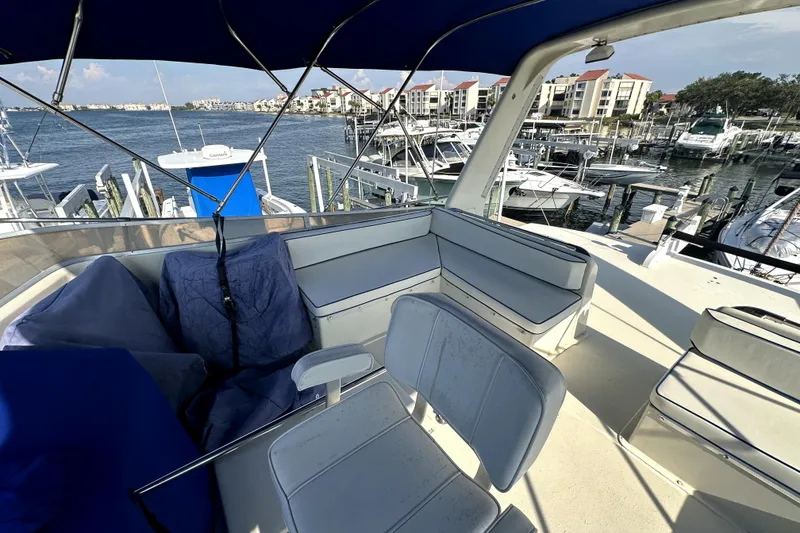 Slide: The Image of 1985 Chris-Craft 500 Constellation yacht interior with marina view, featuring seating and blue canopy. - 113
