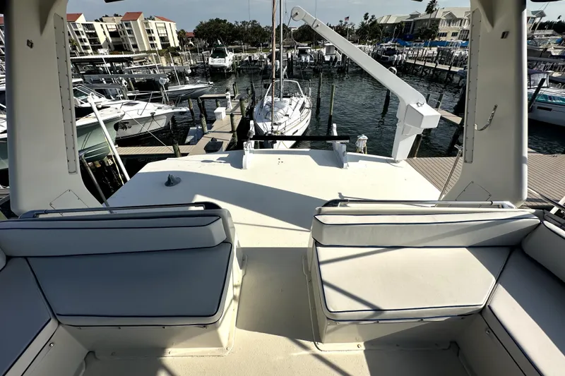 Slide: The Image of 1985 Chris-Craft 500 Constellation yacht deck with marina view, featuring cushioned seating. - 115