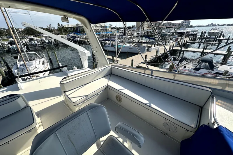 Slide: The Image of 1985 Chris-Craft 500 Constellation yacht interior with marina view, featuring blue and white seating. - 116