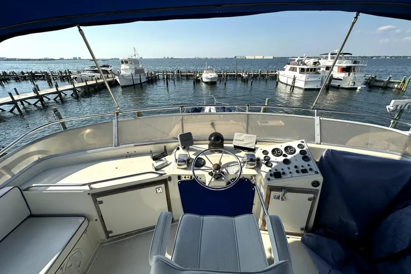 Slide: The Image of Helm of 1985 Chris-Craft 500 Constellation yacht overlooking marina with docked boats. - 118
