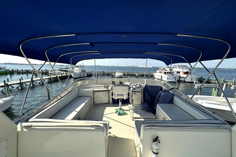 Slide: The Image of 1985 Chris-Craft 500 Constellation yacht with blue canopy, docked at marina. - 121