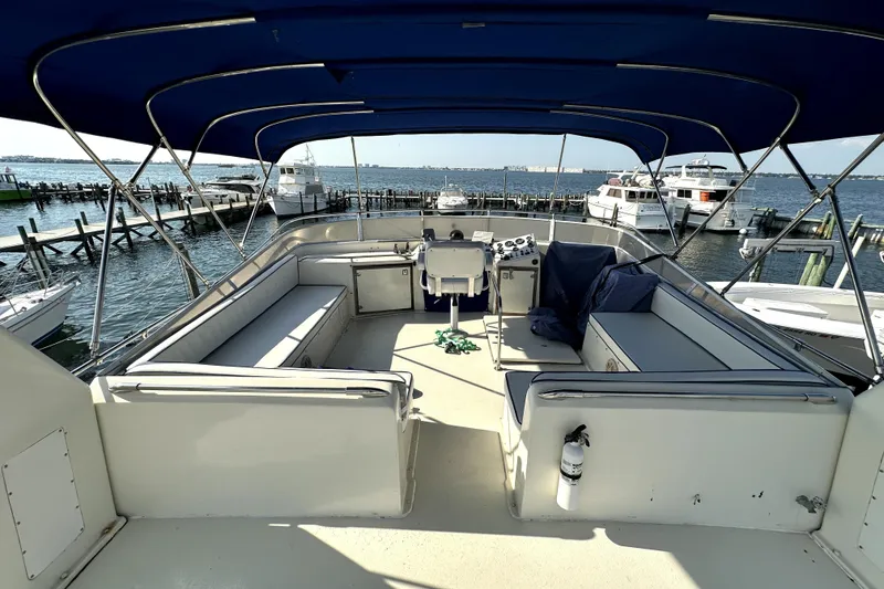 Slide: The Image of 1985 Chris-Craft 500 Constellation yacht deck with seating and canopy, docked at marina. - 122