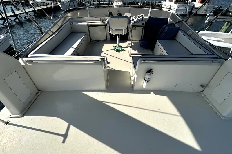 Slide: The Image of 1985 Chris-Craft 500 Constellation yacht deck with seating and helm, docked at marina. - 123