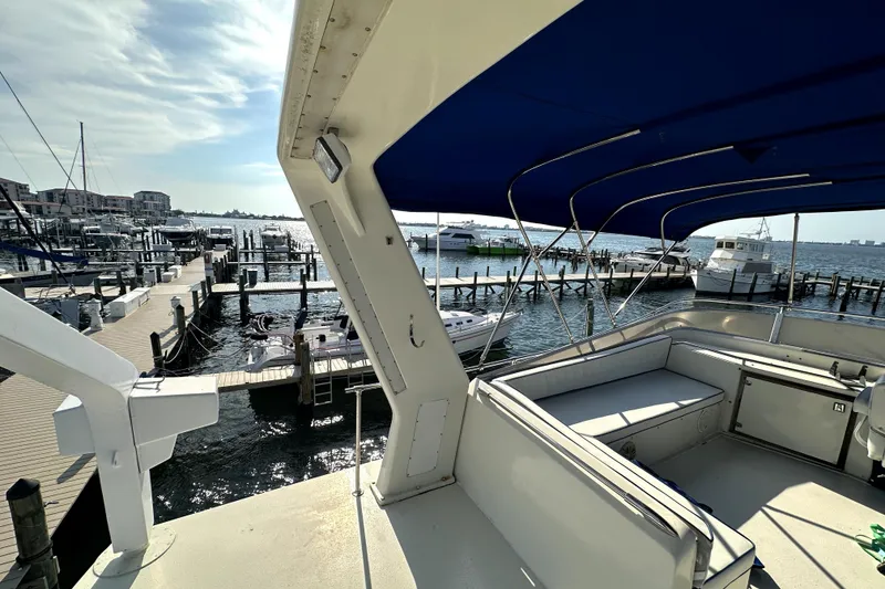 Slide: The Image of 1985 Chris-Craft 500 Constellation yacht docked at a sunny marina with blue canopy. - 124
