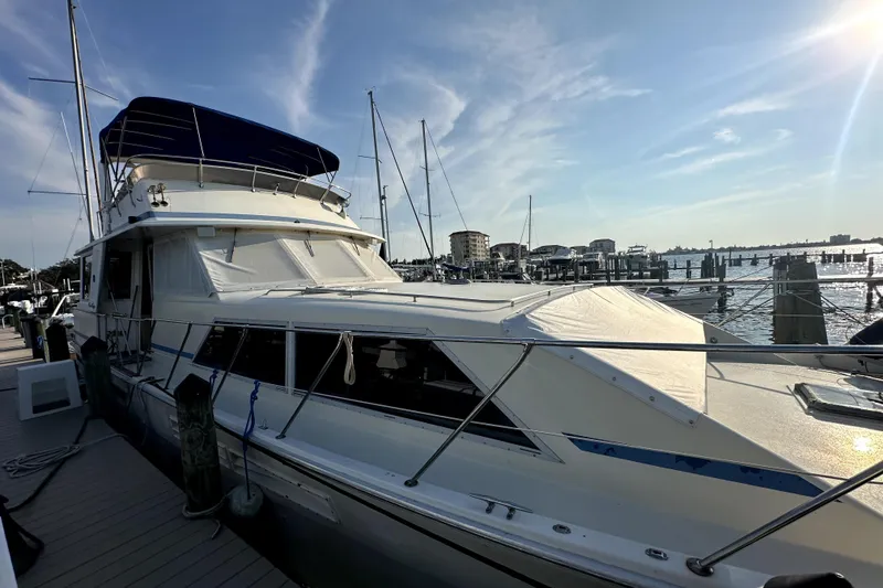Slide: The Image of 1985 Chris-Craft 500 Constellation yacht docked at marina under clear sky. - 128