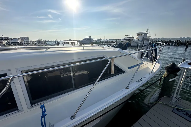Slide: The Image of 1985 Chris-Craft 500 Constellation yacht docked at marina under sunny sky. - 129