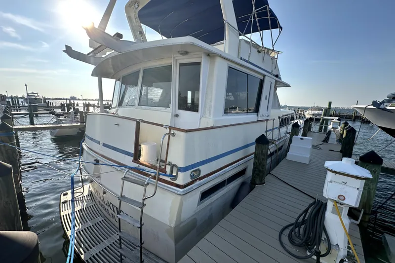 Slide: The Image of 1985 Chris-Craft 500 Constellation yacht docked at marina under sunny sky. - 132