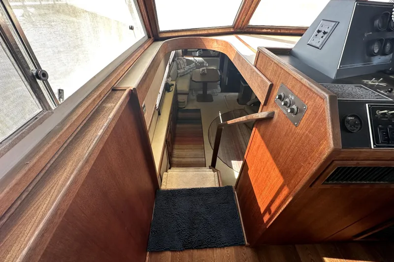 Slide: The Image of Interior view of 1985 Chris-Craft 500 Constellation yacht with wooden paneling and control panel. - 14