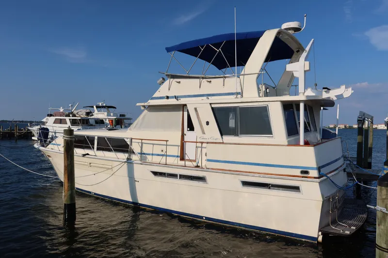 Slide: The Image of 1985 Chris-Craft 500 Constellation yacht docked at marina under clear blue sky. - 140