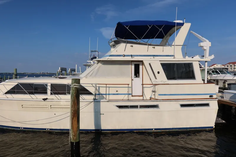 Slide: The Image of 1985 Chris-Craft 500 Constellation yacht docked at marina under clear blue sky. - 141