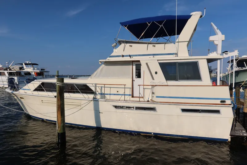 Slide: The Image of 1985 Chris-Craft 500 Constellation yacht docked at marina under clear blue sky. - 142