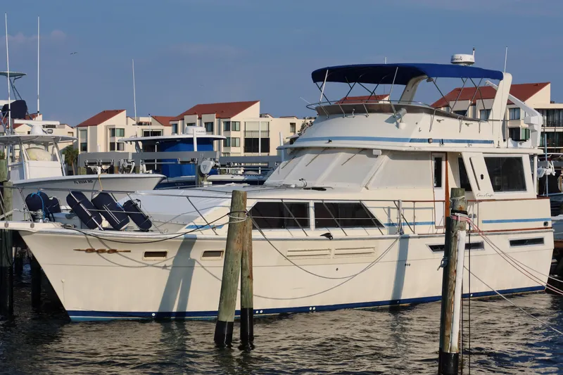 Slide: The Image of 1985 Chris-Craft 500 Constellation yacht docked at marina, featuring classic design and spacious deck. - 144