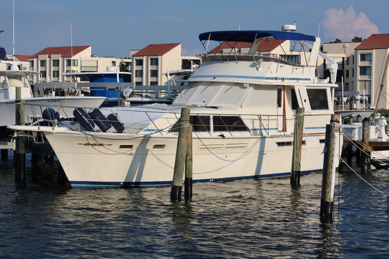 Slide: The Image of 1985 Chris-Craft 500 Constellation yacht docked at marina with modern buildings in background. - 145