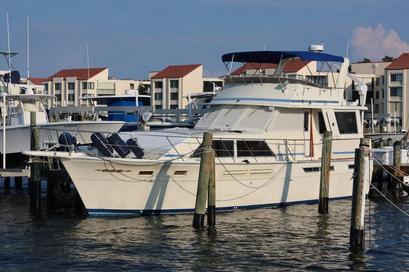 Slide: The Image of 1985 Chris-Craft 500 Constellation yacht docked at marina with modern buildings. - 146