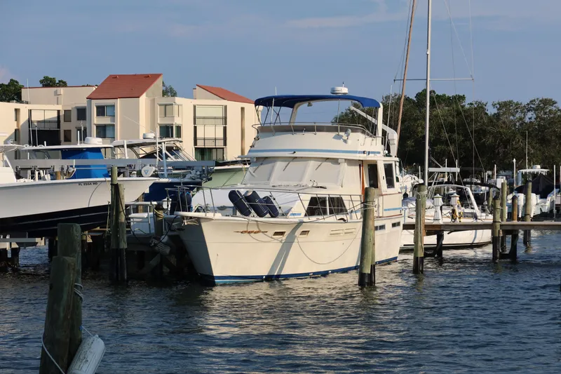 Slide: The Image of 1985 Chris-Craft 500 Constellation yacht docked at marina with modern buildings in background. - 148