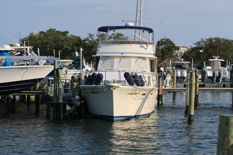 Slide: The Image of 1985 Chris-Craft 500 Constellation yacht docked at a marina, surrounded by other boats. - 150