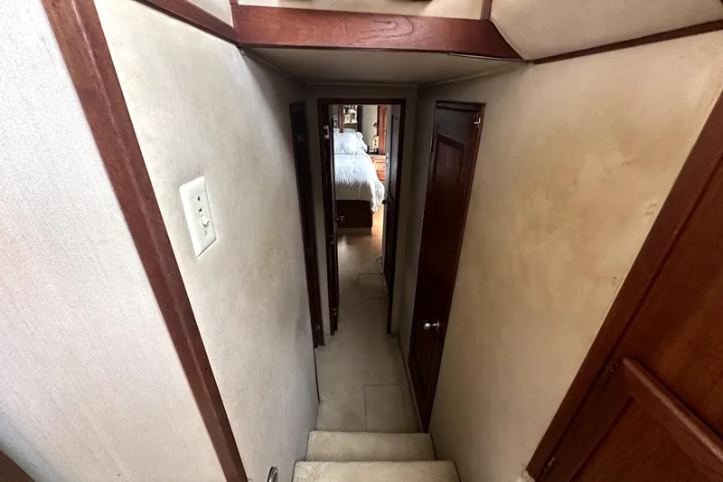 Slide: The Image of Narrow hallway inside 1985 Chris-Craft 500 Constellation yacht, featuring wooden doors and carpeted stairs. - 19