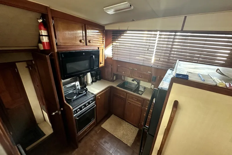 Slide: The Image of 1985 Chris-Craft 500 Constellation yacht kitchen with wooden cabinets and modern appliances. - 30