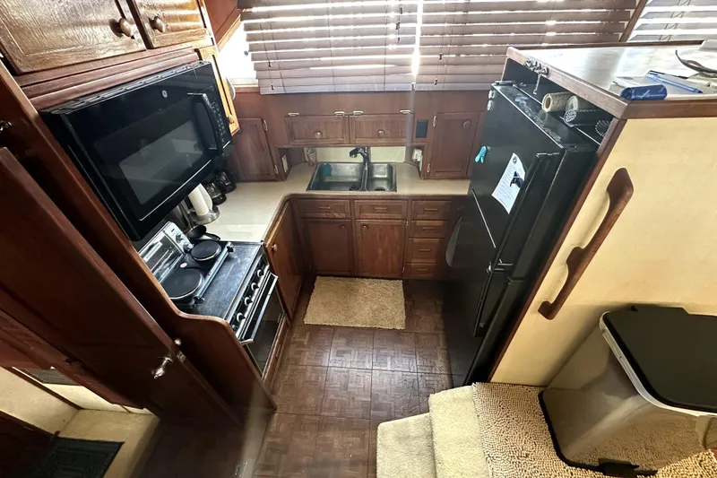 Slide: The Image of 1985 Chris-Craft 500 Constellation yacht kitchen with wooden cabinets and modern appliances. - 31