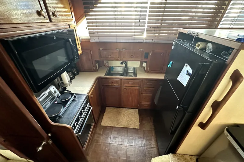 Slide: The Image of 1985 Chris-Craft 500 Constellation yacht kitchen with wooden cabinets and modern appliances. - 32
