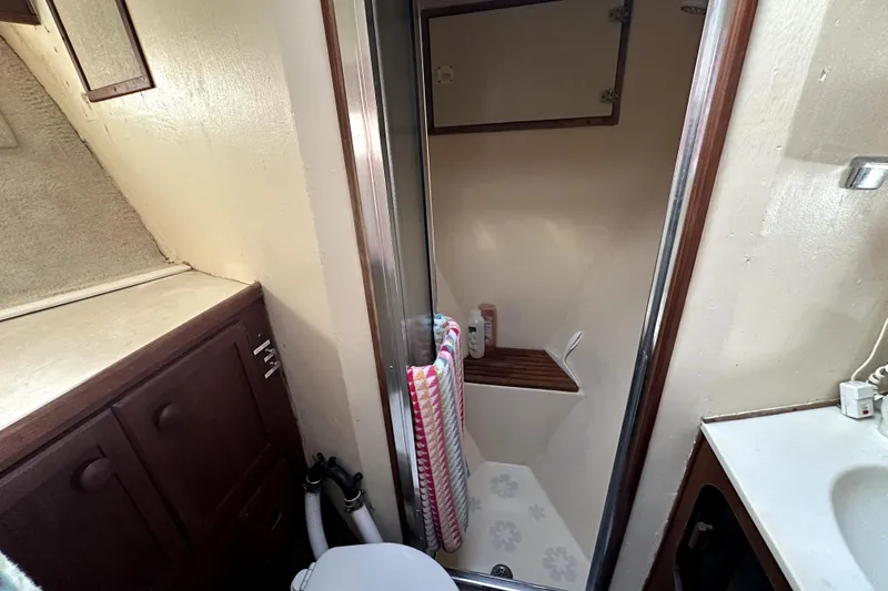 Slide: The Image of 1985 Chris-Craft 500 Constellation bathroom with shower, wooden cabinetry, and countertop. - 41