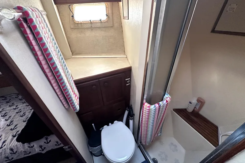 Slide: The Image of 1985 Chris-Craft 500 Constellation yacht bathroom with shower, toilet, and colorful towels. - 42