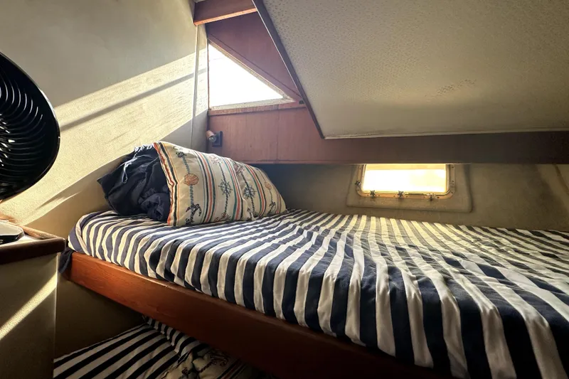 Slide: The Image of Cozy cabin interior of 1985 Chris-Craft 500 Constellation with striped bedding and sunlight. - 45