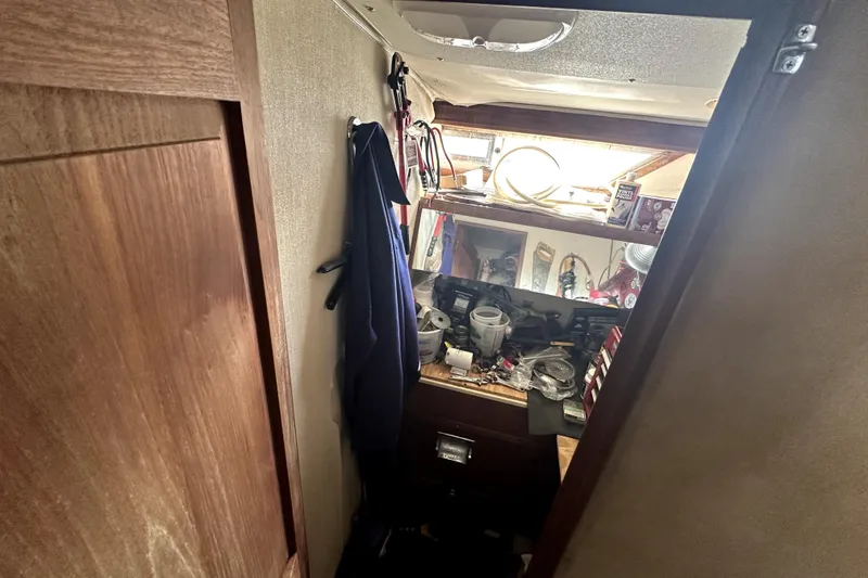 Slide: The Image of Interior view of a 1985 Chris-Craft 500 Constellation, showcasing a cluttered storage area. - 51
