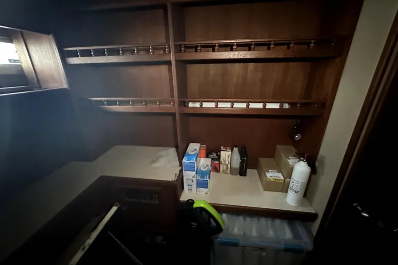 Slide: The Image of 1985 Chris-Craft 500 Constellation interior storage area with shelves and supplies. - 59