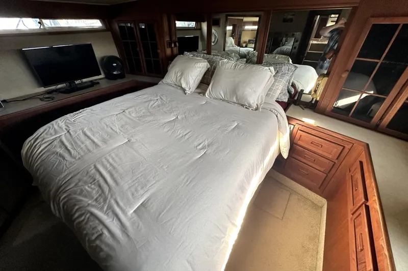 Slide: The Image of Luxurious bedroom interior of 1985 Chris-Craft 500 Constellation yacht with cozy bedding and wooden cabinetry. - 61