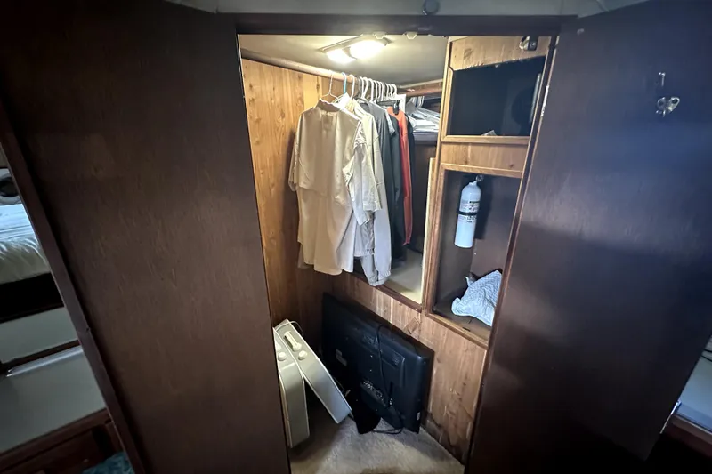 Slide: The Image of 1985 Chris-Craft 500 Constellation closet with clothes, fire extinguisher, and storage shelves. - 65