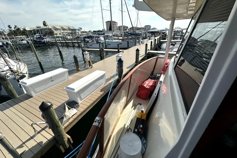 Slide: The Image of 1985 Chris-Craft 500 Constellation docked at marina, showcasing deck and nearby boats. - 7
