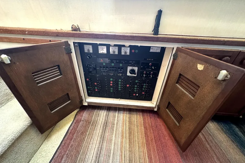Slide: The Image of Electrical panel of a 1985 Chris-Craft 500 Constellation yacht with open wooden doors. - 75