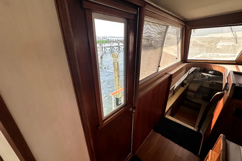 Slide: The Image of Interior view of 1985 Chris-Craft 500 Constellation yacht with wooden finishes and marina view. - 77